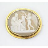 A Victorian shell carved cameo brooch depicting classical scene with Cupid like cherub and a muse,