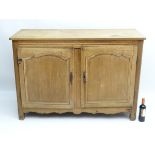 A late 19thC oak sideboard with a rectangular top above two panelled doors containing shelves
