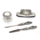 Manicure items comprising silver handled tools, buffer and silver lidded pot.