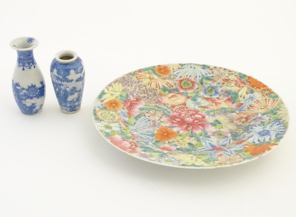 An Oriental plate decorated with stylised flowers, with a scrolling floral design to reverse.