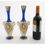 A pair of vases with hand painted Roman portraits in roundels surrounded by scrolling decoration,