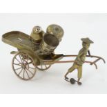 An Oriental three piece white metal cruet held in a wheeled Riksha / Rickshaw with human figure