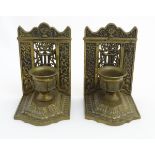 A pair of early - mid 20thC cast brass bookends, formed with scale pedestal fonts on a raised step,