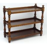 A mid / late 19thC mahogany three tier buffet, standing on turned supports terminating in bun feet.