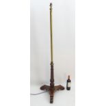 A rosewood tripod standard lamp with acanthus feet and lotus flower decoration to the lower section