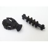 Two Victorian Whitby jet brooches, one formed as a hand with flowers 1 ½” long .