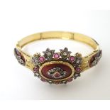 A charming 18ct gold bangle bracelet set with diamonds and rubies and with red guilloché enamelling