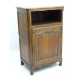 An oak Louis XV style cupboard with paneled sides and a moulded top,