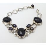A late 20thC silver bracelet set with facet cut onyx and black pearls.