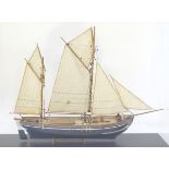 Ship in a case: a scale model of a circa 1900 two masted fishing smack in a perspex case.