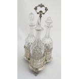 A 19thC silver plate three decanter set and stand, with central carry handle.