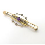A late 19thC / early 20thC 9ct gold brooch set with central amethyst and seed pearls.