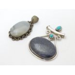 A silver pendant set with large hardstone cabochon and two small turquoise cabochon,