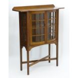 Arts & Crafts: An oak bow fronted display cabinet / bookcase with a raised upstand above a bow