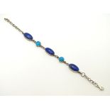 A silver bracelet set with lapiz lazuli and turquoise cabochon.