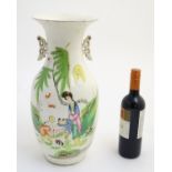 A 20thC Chinese twin handled baluster vase, decorated with figures in a garden with flying lanterns.