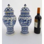 Two blue and white ginger jars decorated with buildings in a landscape,