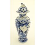 A Chinese blue and white ginger jar decorated with a floral pattern and two panels depicting an