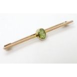 A 9ct gold bar brooch set with oval peridot.