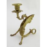 A 19thC cast bronze candlestick / chamberstick in the form of a Wyvern (with glass eyes) holding