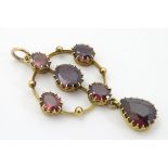 A late 19thC / early 20thC lavalier pendant set with 6 almondine garnets 2" long