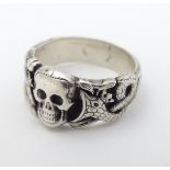 A silver ring with skull and serpent decoration, in the manner of a totenkopf ring. Marked Muller.