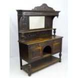 An early 20thC oak sideboard with mirrored back,