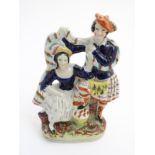 A Victorian Staffordshire pottery figural group of a man and a woman in highland dress,
