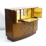 A 1930’s walnut cocktail cabinet, the top opening to reveal fitted shelves and a mirrored back.
