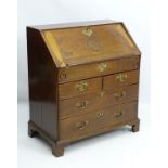 A mid 18thC oak bureau having a carved fall opening to reveal a fitted interior and a well