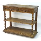 An early 20thC oak buffet with a carved top edge above foliate carved drawers and handles,