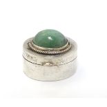 A white metal pill box of oval form with jade cabochon to lid.