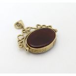 A 9ct gold pendant fob with rotating green and carnelian central fob section.