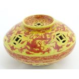 A three-footed Oriental red and yellow circular censer,