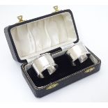 A cased pair of silver napkin rings hallmarked Birmingham 1954/1956 maker Adie Bros Ltd.