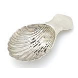 A silver caddy spoon with shell formed bowl.