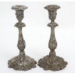 A pair of silver plate candlesticks with profuse fruiting vine decoration.