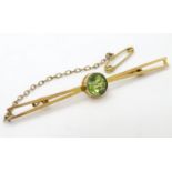 A 9ct gold bar brooch set with central green stone, probably a green amethyst.