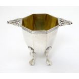A silver octagonal formed salt / pepper base with twin handles and gilded interior.