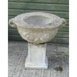 A reconstituted stone urn with associated squared plinth ,