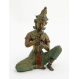A polychromed cast bronze figure of a traditional Thai musician seated and playing a Pi Kaek /