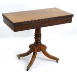 A mid 19thC mahogany tea table with a reeded rectangular top, heavy turned column,