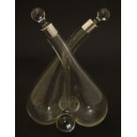Cross oil and vinegar bottles: a glass pair of oil and vinegar bottles of crossed form,