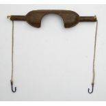 An 18thC/19thC yoke with chains terminating in hooks, as used by country milk maids, etc.