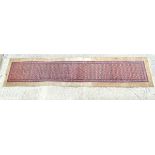Carpet / Rug : a hand woven Signed Runner with a red central ground, blue, navy blue, pink,