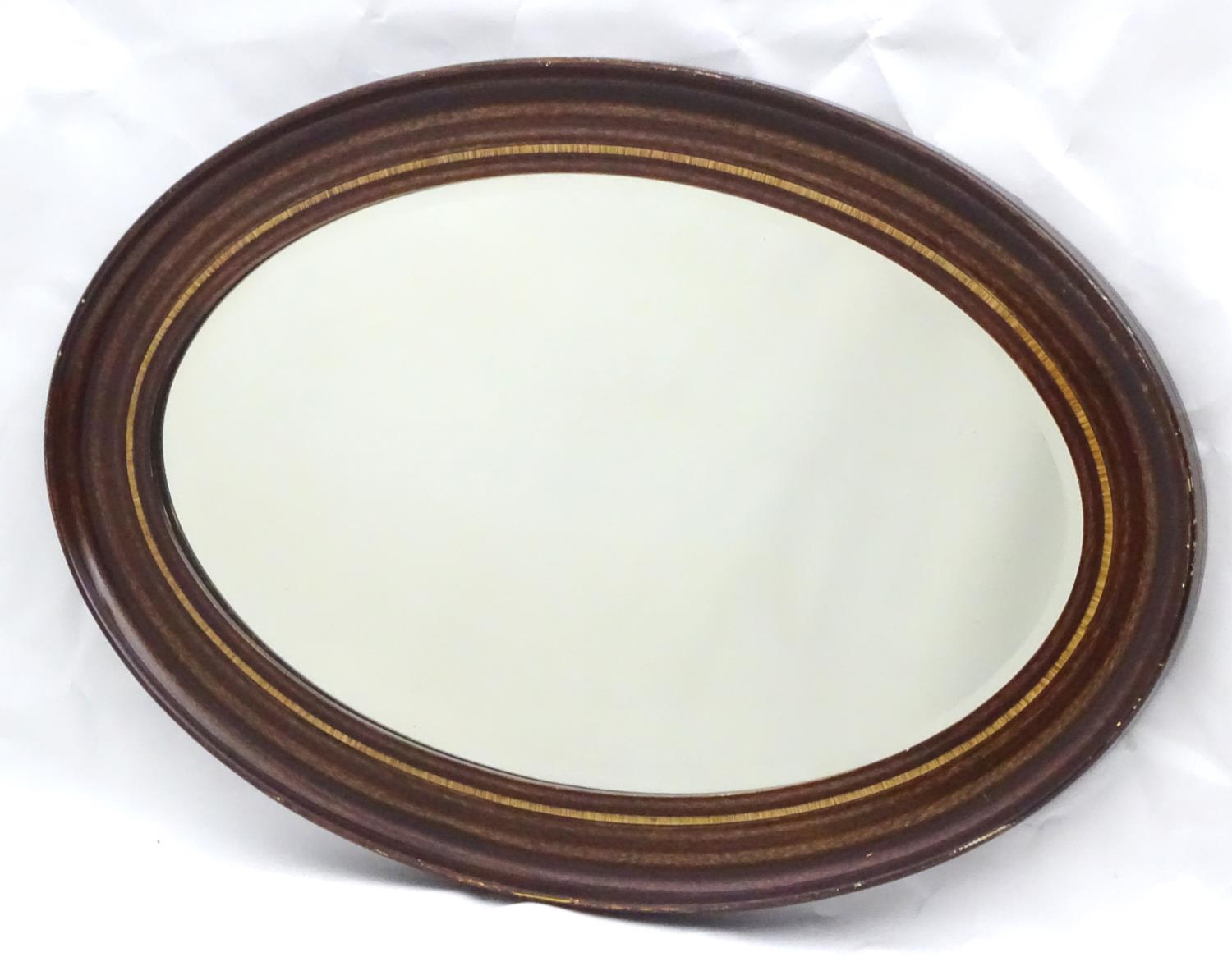 A mid 20thC oval bevelled mirror with crossbanded detailing to the frame. - Image 2 of 10