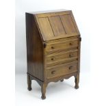 An early 20thC walnut bureau with a paneled fall opening to reveal fitted compartments and drawers