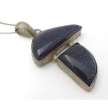 A modernist pendant set with polished hardstone detail 2" long with a 16" silver chain.