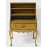 An early 20thC pine cabinet with sloped open shelves to the front above a single short drawer with