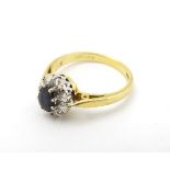 A Vintage 1970's 18ct gold ring set with central sapphire bordered by diamonds